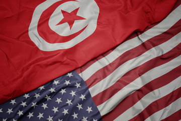 Obraz premium waving colorful flag of united states of america and national flag of tunisia.