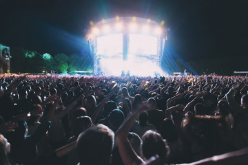 A big concert crowd having fun in front of the stage.