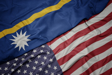 waving colorful flag of united states of america and national flag of Nauru.