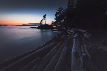 Stunning lighthouse sunsets on a rocky beach with mountains surrounding.  Bowen Island BC Canada.  Close to downtown Vancouver.
