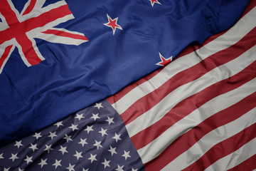 waving colorful flag of united states of america and national flag of new zealand.