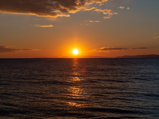 Amazing sunset over the sea with distant islands in the background