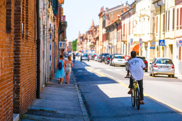 Ferrara, Italy - July, 11, 2019: bicyclist on a road in Ferrara, Italy