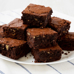 Homemade chocolate brownies on a white plate, side view. Closeup.