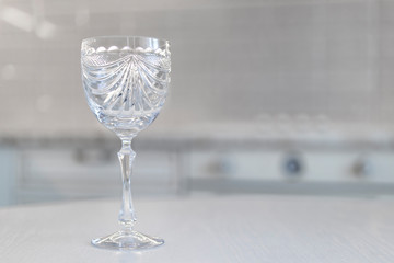 vintage crystal glass with engraving on a white moan against the background of the kitchen in...