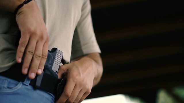 Pistol. Guy hides a gun under his clothes