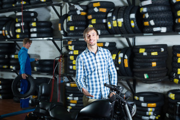 Young man customer holding his motorcycle