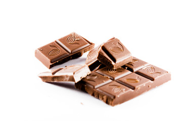 Ounces of chopped sweet chocolate, chocolate bars on a white background.