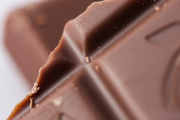 Ounces of chopped sweet chocolate, chocolate bars on a white background.