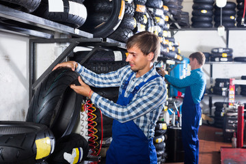 worker holding new tyre