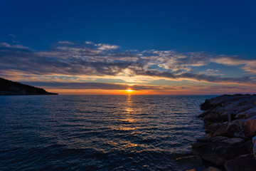 Beautiful sky with clouds at sunset over Adriatic sea near Peschici town on Gargano peninsula, Italy