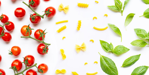 Cherry tomatoes with different types of pasta and basil leaves on white. Italian food concept