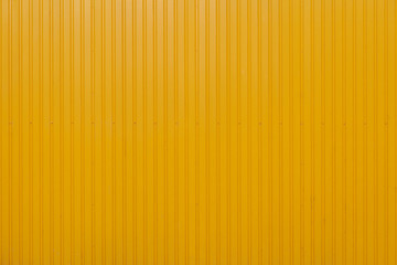 Yellow metal sheet panel or cladding with vertical line wave pattern.