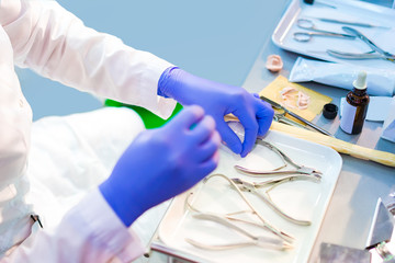 The surgeon prepares medical instruments. Preparing for the operation. A woman in gloves is preparing medical equipment. Clinic treatment. Surgery.