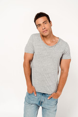 handsome mixed race man standing with hands in pockets and looking at camera on white