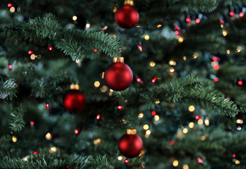 Glowing Christmas tree decorated with red and gold ornament balls for the holiday season 