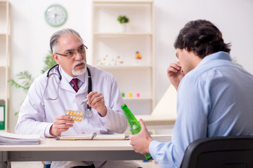 Young male alcoholic visiting old doctor