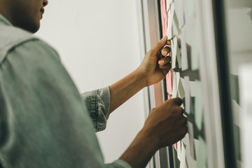 business people post it notes in glass wall at meeting room, teamwork concept