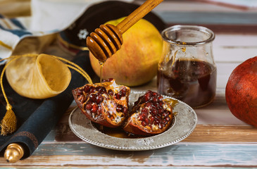 Apple, pomegranate and honey of jewish New Year Rosh Hashana torah book, kippah yamolka talit
