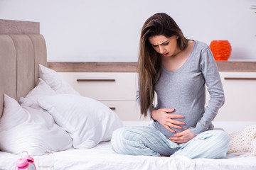 Young pregnant woman in the bedroom