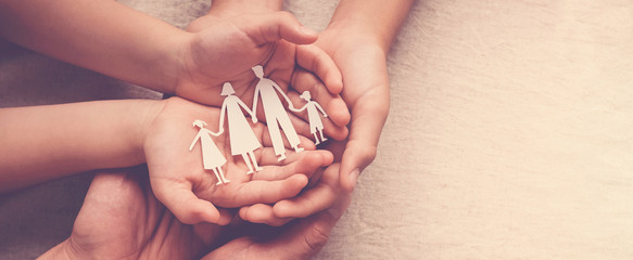 hands holding paper family cutout, family home,life insurance, adoption foster care, homeless...