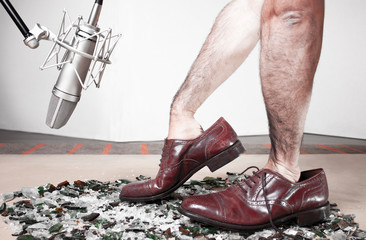 Foley man steps recording with soundman hands inside male dress shoes. 