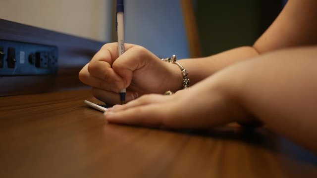 Woman writing dramatic note on desk