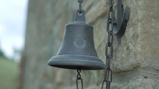 An ancient bell next to a castle in slow motion. This clip is in sixty frames per second converted to twenty five frames per second.