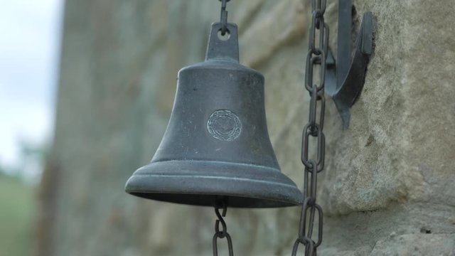 An ancient bell next to a castle. This clip is in sixty frames per second.