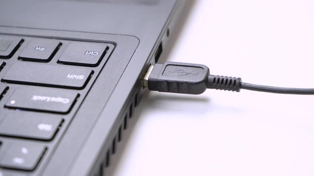 USB flash drive connected to a Laptop. Hand disconnecting Usb flash drive cable to computer. Plug / unplug flash drive to netbook. 4K (UHD)