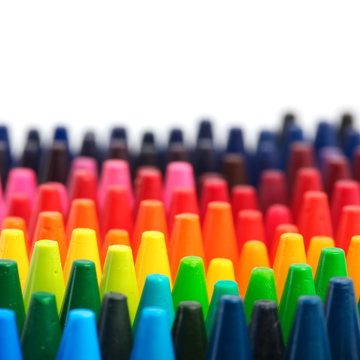 Box of crayons in a rainbow of colors with blank white space