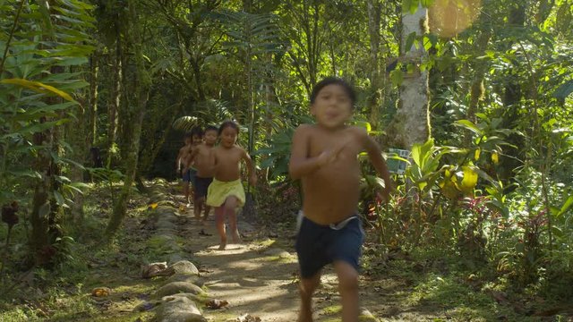 Indigenous Kids Running Through A Path Around Amazon Village In Ecuador