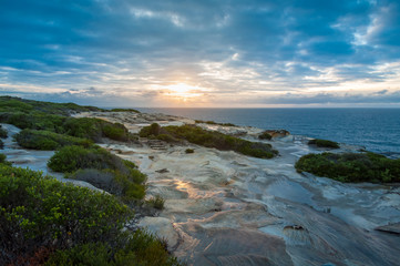 Fototapeta na wymiar Beuatiful sunrise seascape with rocky coastline and open ocean