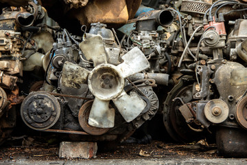 Pile old machine parts and scrap metal of car engine at second hand machinery shop.