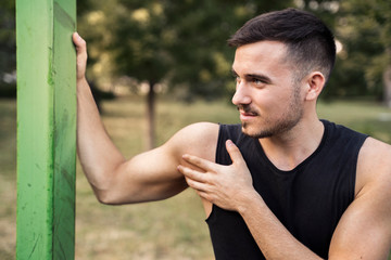 Man stretching arms before workout outdoors 