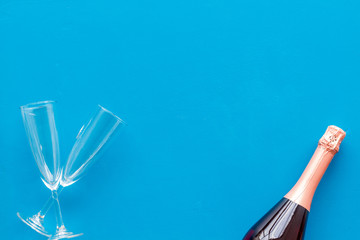 Champagne bottle with glasses for celebration on blue background top view mock up