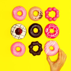 Sweet Donuts set on a yellow background. Flat lay fast food minimal art