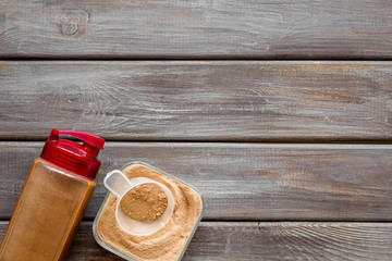 Sports nutrition with scoop and protein, shaker on wooden background top view space for text