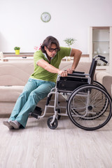 Young male invalid in wheelchair suffering at home