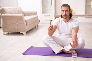 Fototapeta premium Young man doing physical exercises at home