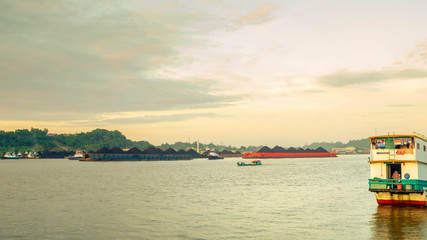 Fototapeta premium the traffic of tugboat dragging barge full of coal at Mahakam River, Samarinda, Indonesia. Industrial and mining background
