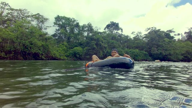 Indigenous Boy Having Fun Over A River Inner Tube On The Amazon Rainforest
