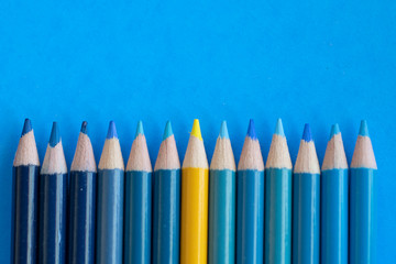 Up Close blue coloring pencils with one yellow coloring pencil on a blue background