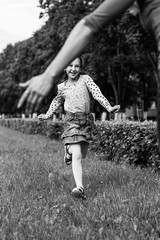 Little cheerful girl running through the grass.