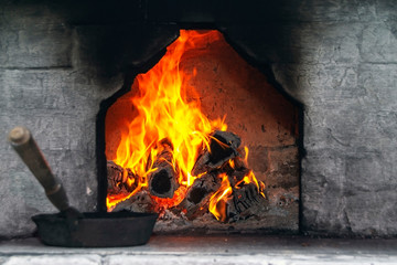 In a real Russian stove, firewood burns. Bright flame of fire.