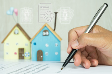 Businessman writing signature in documents agreement contract for family and buy new house or property investment project with minimal home. Investment mortgage agent marketing in real estate concept.