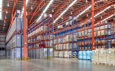 High shelves of cargoes inside large distribution warehouse. Fulfillment center, logistics and...