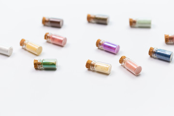 Cosmetics, makeup and beauty concept - Colourful eye shadow in small glass boxes on white background, top view close up.