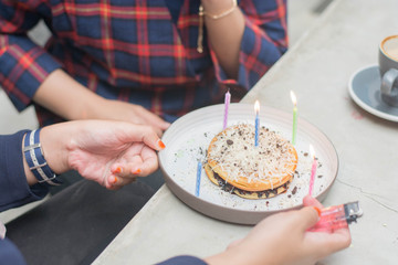 close up portrait of hand light up candle in pancake to preparing surprise birthday party
