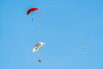Skydiving adventure with parachutes against clear blue sky on a sunny day